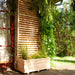 Jagram Venetian larch planter in a planted garden setting